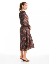 Vestido midi de manga larga con escote en V, confeccionado en tela fluida con estampado abstracto multicolor. Presenta una cintura elástica fruncida que define la silueta y una falda con caída suave y movimiento.