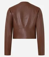 Campera básica de cuero sintético (PU) color marrón oscuro, con cuello redondo, cierre frontal y recortes decorativos. Cuenta con mangas largas y bolsillos con cierre.