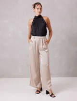 Blusa de satén color negro con diseño plisado, cuello alto tipo halter y corte sin mangas.