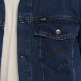Campera Wrangler de denim azul con cuello clásico, cierre frontal con botones metálicos, bolsillos con solapa abotonada en el pecho y bolsillos laterales.