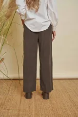 Pantalón de pana fina color marrón, de pierna ancha, con elástico en la cintura y bolsillos laterales. Incluye un cinturón de tela a juego.