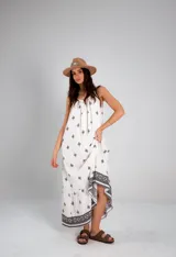 Vestido blanco con estampado de cruces negras, sin mangas y corte holgado.
