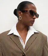 Blazer de sastrería con estampado pied de poule, corte estructurado, cuello con solapa clásica, cierre frontal de tres botones y bolsillos con solapa.