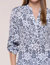 Blusa Zac & Rachel de gasa estampada con diseño floral en tonos violeta y marrón. Cuenta con cuello en V, escote con botones frontales, detalles plisados en el frente y mangas largas con presilla para regular su largo.