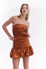Top strapless de color rosa metalizado con diseño drapeado y detalle frontal con forma de pañuelo.