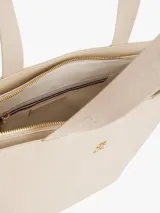 Cartera tipo tote color beige con acabado liso, doble asa superior de cinta y logotipo metálico dorado de la marca en la parte frontal. Cuenta con compartimiento principal con cierre de cremallera.
