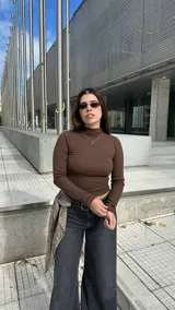 Polera marrón de manga larga, con cuello alto y calce ajustado al cuerpo.