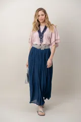 Pollera larga de color marrón, confeccionada en tela liviana con textura sutil y diseño plisado. Incluye un cinto rústico trenzado.