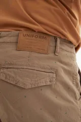 Bermuda cargo color beige con pequeños lunares verdes, bolsillos laterales con solapa y ruedo con dobladillo.