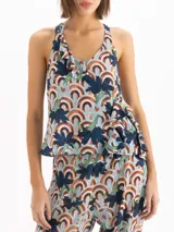 Top de crepe de viscosa con estampa exclusiva de motivos geométricos y florales. Presenta escote en V con volados y breteles fijos que se cruzan en la espalda.