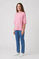 Sweater de punto color rosado, de corte ancho, cuello redondo y mangas medias con puños elásticos.