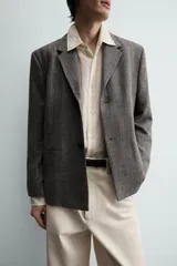 Blazer de corte slim fit confeccionada en tejido con viscosa, con cuello de solapas de muesca, cierre frontal de un botón, bolsillos de solapa en la cadera y bolsillo de vivo en el pecho.