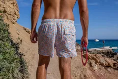 Short de baño Von Braun con estampado de arcos en tonos naranja y azul sobre fondo blanco. Cuenta con cintura elástica, dos bolsillos laterales, un bolsillo trasero con etiqueta de la marca y red interior.