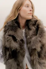 Chaleco de piel sintética en tono marrón, con diseño de pelo largo y voluminoso, ideal para superposiciones.