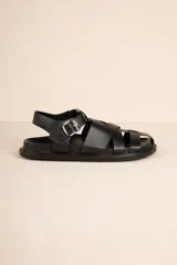 Sandalias bajas tipo gladiador, color negro, con tiras entrelazadas y hebilla metálica ajustable.