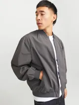Campera bomber liviana color gris oscuro, con cierre frontal de cremallera, cuello baseball, bolsillos funcionales y puños elásticos acanalados.