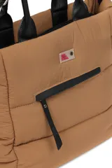 Bolso tipo tote color negro, con diseño acolchado y manijas fijas. Cuenta con una correa larga ajustable y desmontable, cierre principal superior y un bolsillo frontal con cierre.