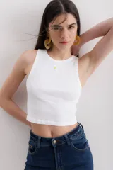 Musculosa corta blanca de algodón con cuello redondo y bordado de una margarita en el pecho.