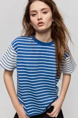 Remera de manga corta con diseño a rayas horizontales azules y blancas, corte relajado y cuello redondo.