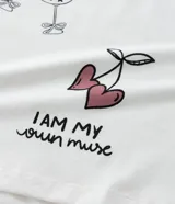 Blusa de algodón blanca con cuello redondo y manga corta abullonada. Estampa con corazones, copas y texto.