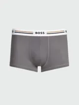 Bóxer de hombre Boss color gris, con cintura elástica blanca y franjas horizontales en tonos negro y tostado con el nombre de la marca en el centro.