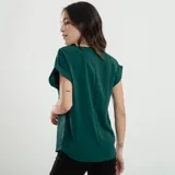Blusa verde esmeralda de mangas cortas con doblez, escote en V y cierre frontal con cremallera dorada.