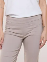 Pantalón color beige de corte entallado y largo cropped, confeccionado en tejido de punto con elasticidad técnica. Cuenta con pretina ancha y plana, bolsillos simulados al frente y bolsillos tipo ojal en la parte posterior.
