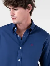 Camisa lisa de hombre color celeste, confeccionada en algodón con acabado vintage, corte regular fit, cuello button-down, cierre frontal de botones y logo bordado en el pecho.