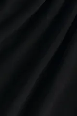 Top de manga corta en punto suave, con escote redondo y panel drapeado adelante que crea una silueta asimétrica.