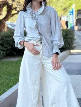 Pantalón ancho color crudo con pespuntes en marrón chocolate, confeccionado en tela con mezcla de jean y lino.