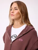 Canguro con cierre frontal de la marca Rusty, en color beige. Presenta capucha, bolsillos tipo canguro y logo bordado en el pecho.