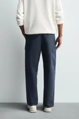 Pantalón cargo de corte regular fit, confeccionado en tejido ligero de algodón. Presenta bolsillos laterales tipo cargo con solapa, bolsillos frontales y bolsillos traseros de vivo. Cierre frontal con cremallera y botón.