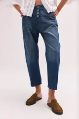 Pantalón de jean de tiro bajo y calce relajado, con cierre frontal de múltiples botones visibles y largo al tobillo.