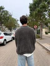Sweater de punto con diseño de trenzas verticales, color gris oscuro con efecto lavado, de corte holgado y fit boxy, con cuello redondo y puños acanalados.