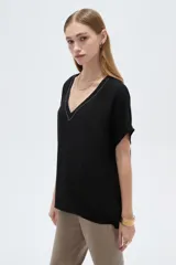 Blusa blanca de poliéster de corte holgado, con escote en V y mangas cortas.