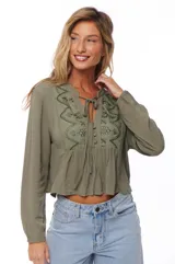 Blusa color verde militar, de corte crop y mangas largas, con escote en V con lazos y bordados en el frente.
