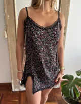 Camisolín corto negro con estampado floral multicolor, breteles finos regulables y detalles de encaje negro en escote y ruedo. Presenta tajo lateral.