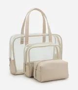 Kit de tres neceseres de diferentes tamaños en color beige. Incluye un neceser grande transparente con manijas, un neceser mediano transparente y un neceser pequeño opaco con textura, todos con cierre de cremallera.