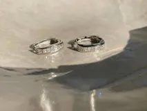Par de aros tipo argolla de plata 925 con acabado en oro de 18k, adornados con circonias cúbicas.