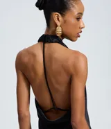 Vestido midi de satén color negro, con escote degagê drapeado y espalda abierta con tiras ajustables. Presenta un corte fluido y elegante.