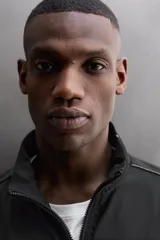 Chaqueta negra regular fit, confeccionada en tejido técnico con algodón. Presenta cuello subido, manga larga, forro interior de red y abertura en la espalda para transpiración. Incluye bolsillos con cierre de cremallera en la cadera, acabados elásticos y cierre frontal con cremallera.