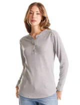 Buzo de tejido fino tipo henley, color gris melange, con escote redondo y cierre frontal parcial con botones. Presenta detalles en tejido acanalado en hombros, puños y ruedo, con terminación redondeada en la parte inferior.