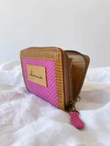 Billetera pequeña con cierre metálico, cuerpo principal en tejido texturizado color fucsia y detalles en cuero marrón con textura de reptil. Posee un parche de cuero claro con la palabra "chowie" escrita a mano.