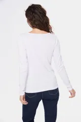 Buzo de tejido de punto con diseño bicolor, combinando blanco en la parte superior y mangas con un tono celeste grisáceo en el cuerpo, presentando un patrón geométrico en la unión de los colores. Posee cuello redondo y mangas largas.