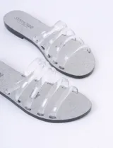 Sandalias planas plateadas con tiras transparentes de silicona.