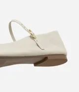 Bailarina de cuero color marrón con puntera cuadrada, taco plano y tira ajustable con hebilla metálica sobre el empeine.