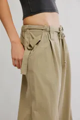 Pantalón chino de tiro bajo, color negro, pierna muy ancha, con cintura elástica con cordón ajustable y pinzas en la parte superior.