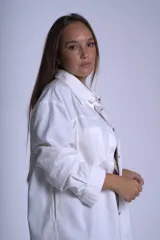 Sobrecamisa color beige confeccionada en gabardina, de corte holgado, con cuello camisero, cierre frontal con botones, dos bolsillos de parche en el pecho y mangas largas con puños abotonados.