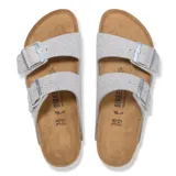 Sandalias Birkenstock modelo Arizona con dos tiras ajustables con hebilla metálica, confeccionadas en material sintético Birko-Flor con acabado brillante plateado con purpurina. Plantilla anatómica de corcho y látex con suela de EVA.