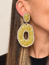Aros colgantes artesanales de resina y metal plateado, con diseño texturizado en tonos celestes y plateados, adornados con bordes de strass.